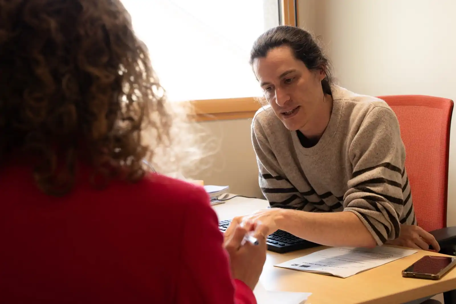 Une entrepreneure en rendez-vous avec un conseiller de l’équipe, devant un ordinateur.